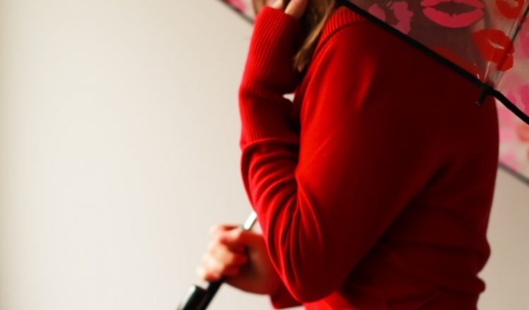 woman in red long sleeve shirt holding umbrella