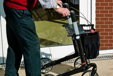 Pensioner wallking using a rollator at a Care Home