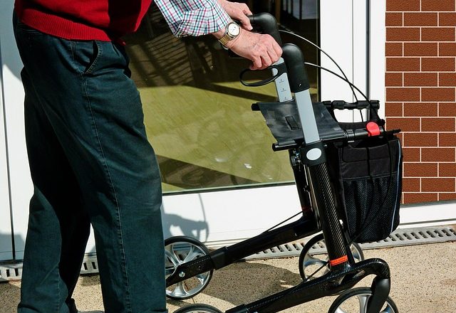 Pensioner wallking using a rollator at a Care Home